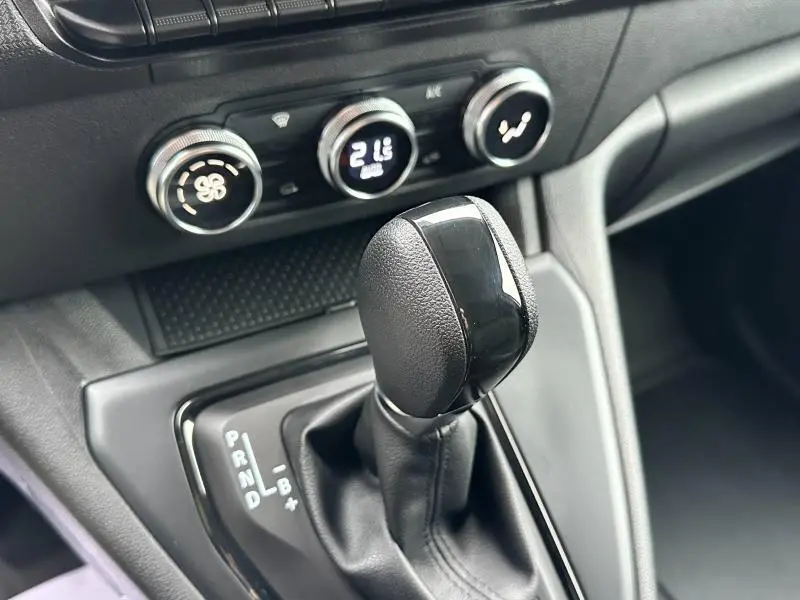 Gros plan sur le levier de vitesses automatique noir et la console de climatisation du Nissan Townstar gris électrique 2024.