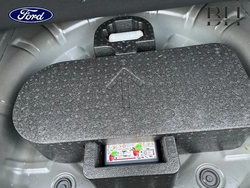 Vue rapprochée du coffre d'une Ford Focus SW 2024 noir Agate, montrant le rangement sous plancher en mousse.