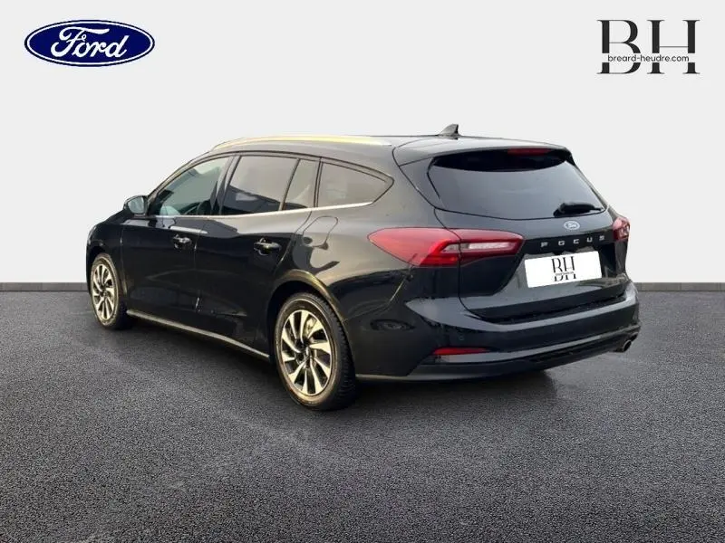 Vue 3/4 arrière droite d'une Ford Focus SW 2024 noir Agate métallisé avec vitres surteintées et feux arrière LED.