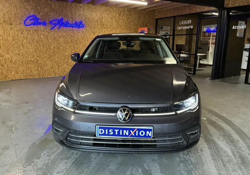 Vue avant d'une Volkswagen Polo gris métallisé 2022 avec phares LED allumés dans un garage.