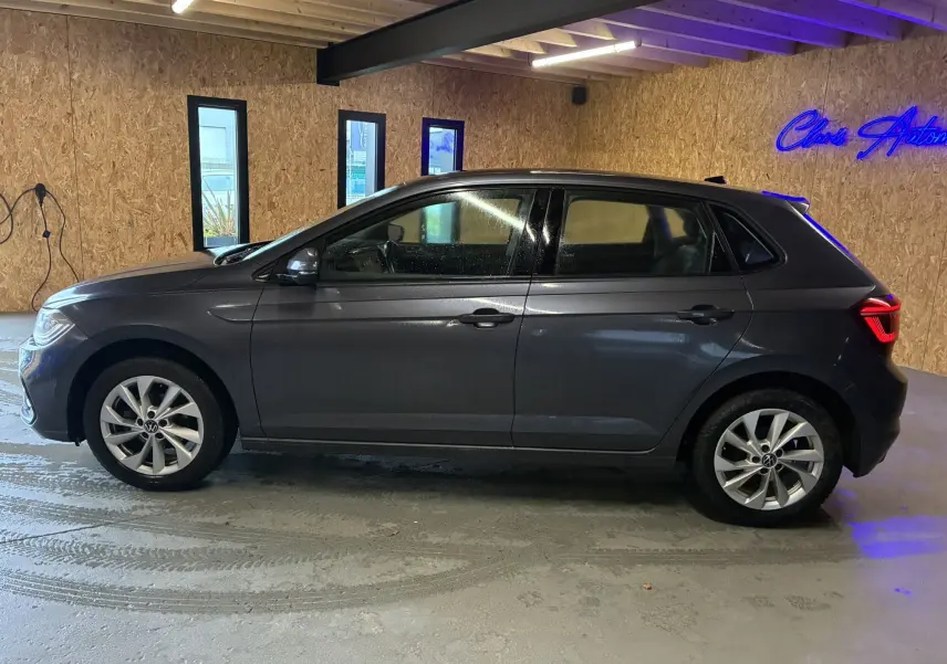 Vue de profil côté gauche d'une Volkswagen Polo gris 2022 avec jantes alliage et rétroviseurs assortis au véhicule.