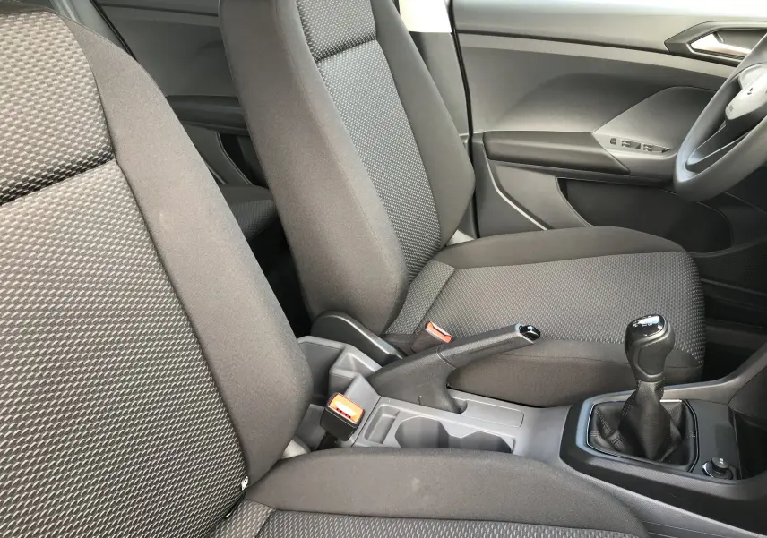 Intérieur du Volkswagen T-Cross 2020 montrant les sièges en tissu noir et la boîte manuelle côté conducteur.
