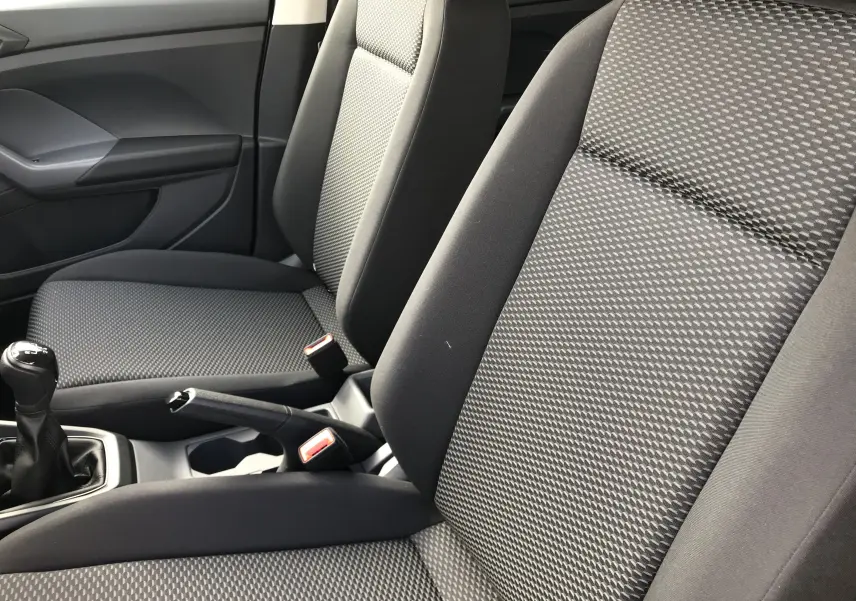 Gros plan sur les sièges avant en tissu noir et gris du Volkswagen T-Cross 2020 avec levier de vitesse manuel visible.