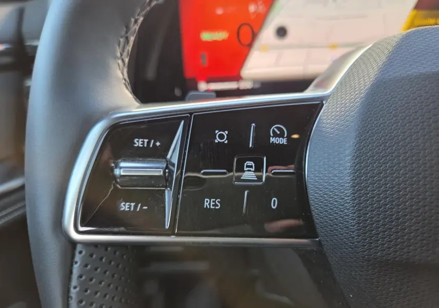 Gros plan sur les commandes du volant du Renault Austral 2025, finition E-Tech hybride, avec écran tactile en arrière-plan.