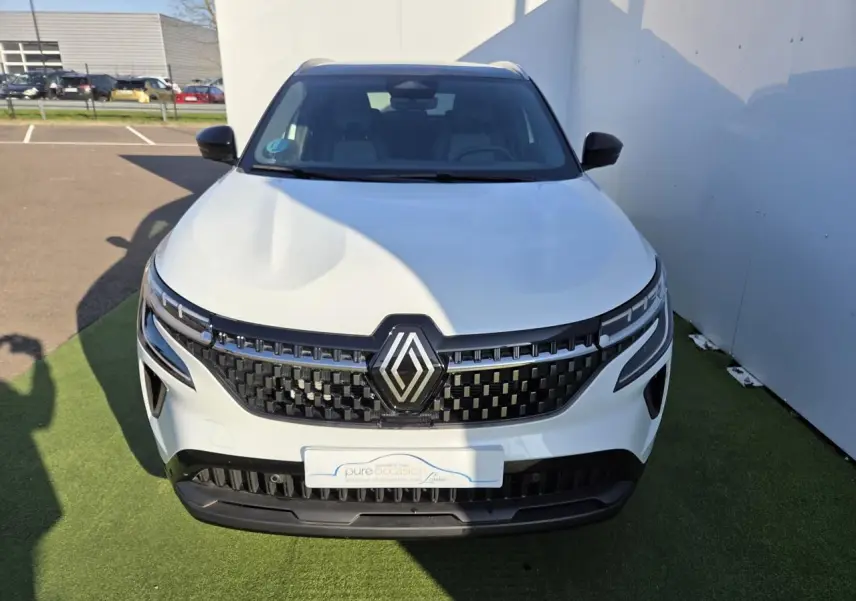 Vue avant du Renault Austral blanc nacré avec toit noir, mettant en valeur la calandre noire et les phares LED distinctifs.