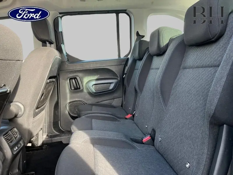 Vue intérieure côté droit des sièges arrière gris foncé du Peugeot Rifter 2020 avec porte latérale et appuie-têtes visibles.