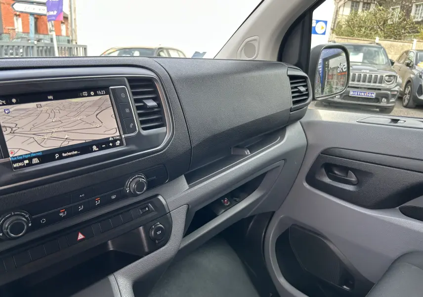 Vue intérieure côté passager de l'Opel Vivaro Combi 2022, tableau de bord noir avec écran tactile et commandes climatisation.