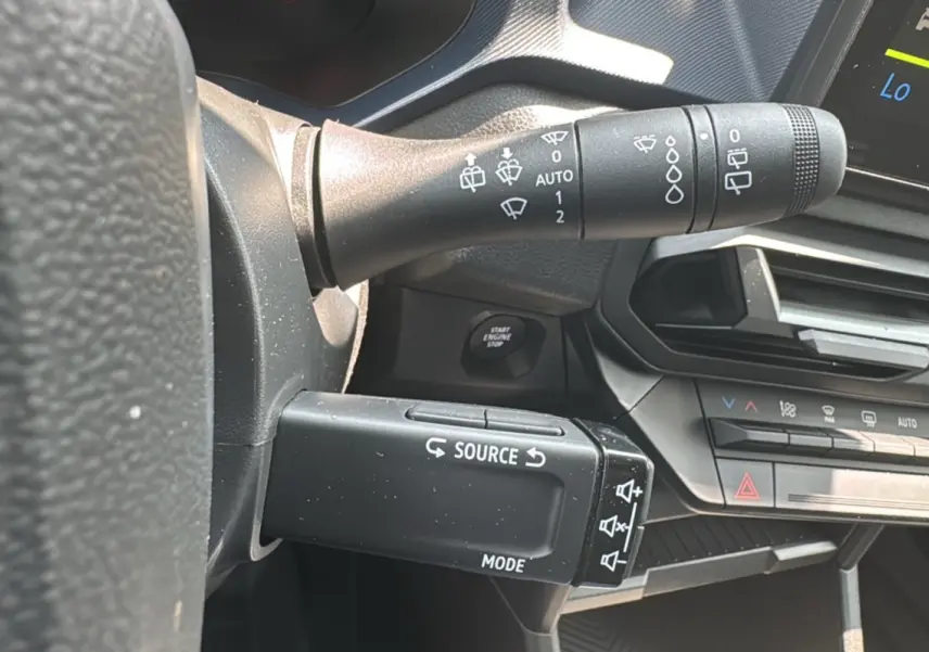 Gros plan sur la commande de régulation audio et le commodo d’essuie-glace dans l’habitacle du Dacia Duster 2025.