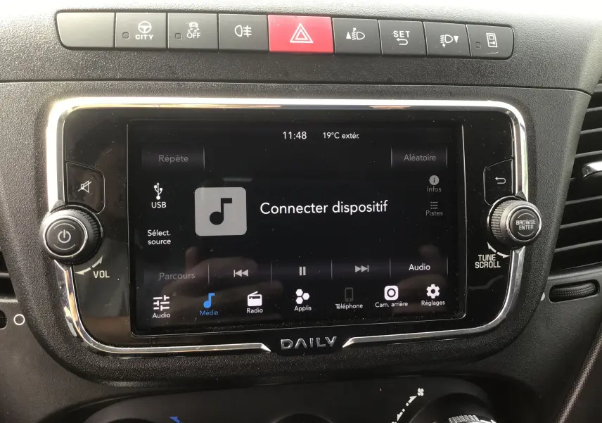 Écran tactile central du tableau de bord du Iveco Daily Chassis Cabine blanc, avec commandes multimédia et climatisation visibles.