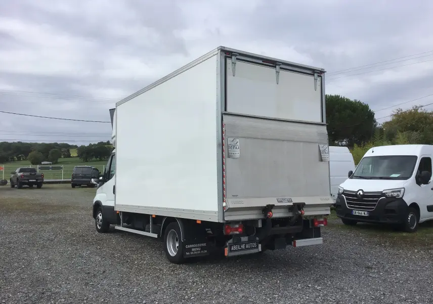 IVECO Daily Chassis Cabine blanc vu de l'arrière droit avec caisse 20m3 et hayon élévateur déployé.