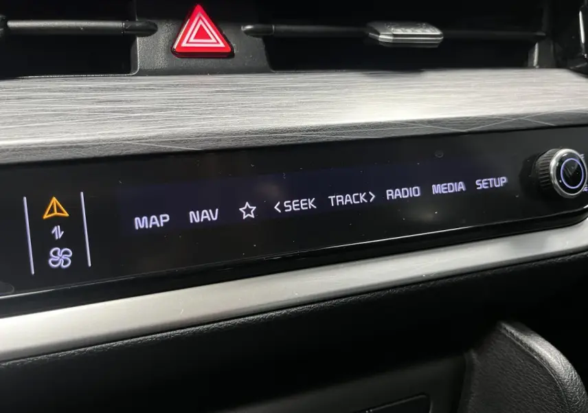Détail de la console centrale du Kia Sportage 2022, écran tactile avec commandes multimédia et bouton rotatif.