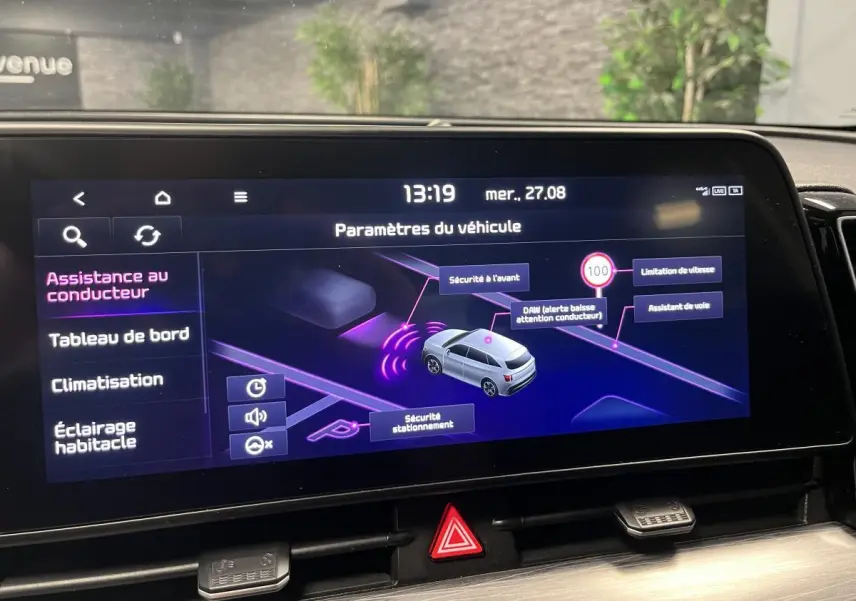 Écran tactile intérieur du Kia Sportage blanc montrant les paramètres d'assistance au conducteur.