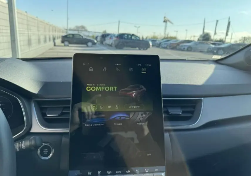 Vue intérieure du tableau de bord du Renault Captur II, écran tactile central affichant le mode Confort, volant partiel visible.