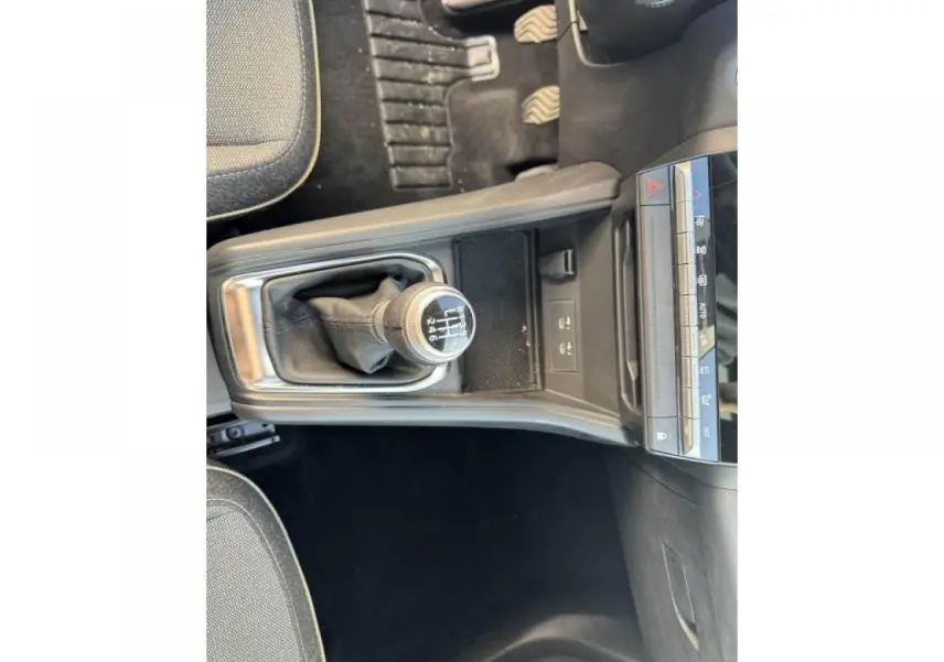 Vue plongeante sur la console centrale et levier de vitesses manuelle du Renault Captur II, intérieur noir.