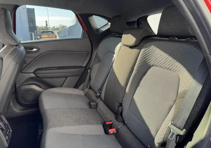 Vue intérieure côté droit de la banquette arrière grise du Renault Captur II avec appuis-tête et ceintures visibles.