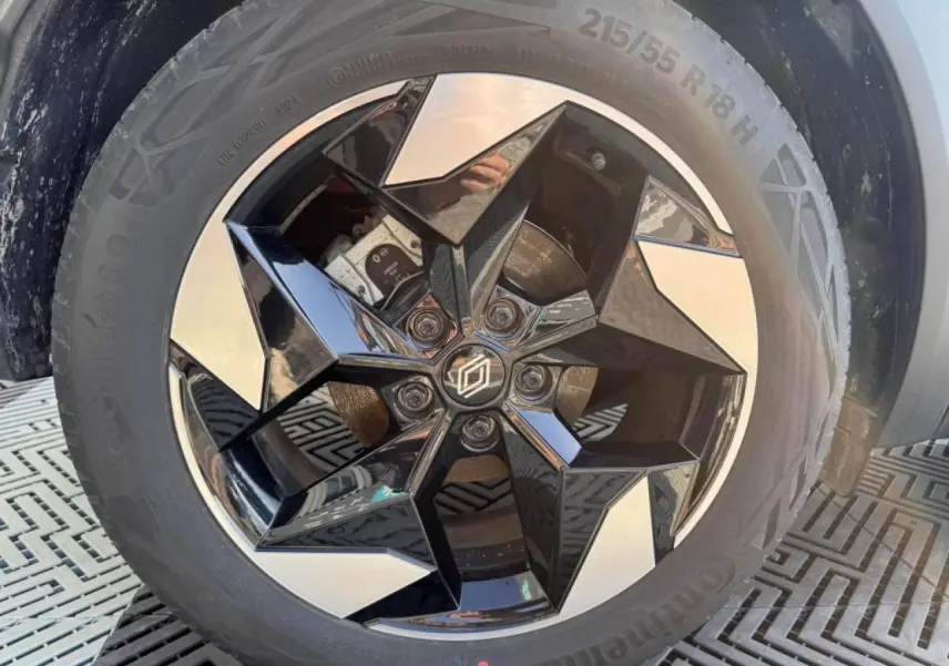 Gros plan sur la jante aluminium 18 pouces noire et argentée du Renault Captur II Rouge Flamme toit noir.