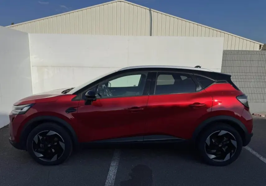 Profil côté gauche du Renault Captur II rouge flamme avec toit noir étoilé et jantes aluminium noires.