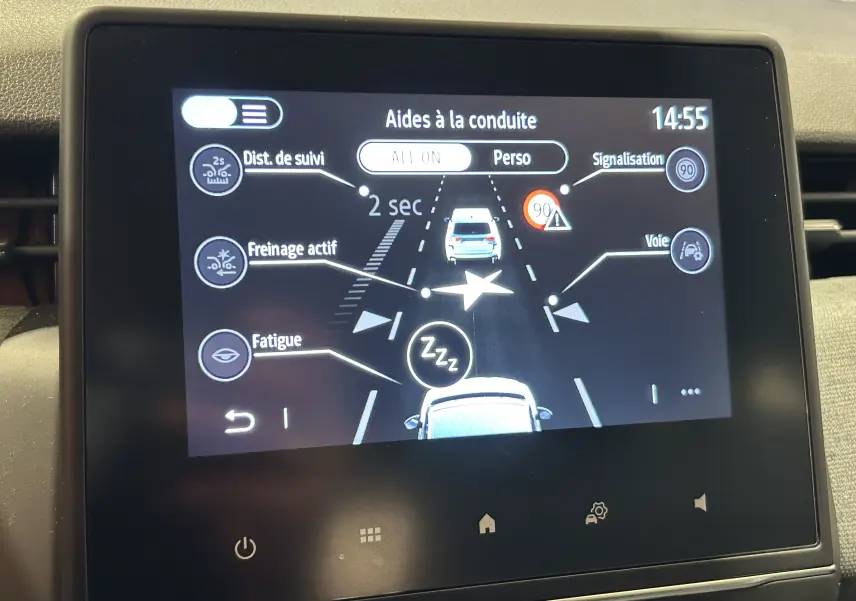Écran central de la Renault Clio V blanc montrant les aides à la conduite avec alertes et réglages.