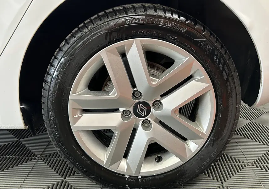 Gros plan sur la roue arrière droite d'une Renault Clio V blanche, mettant en valeur le pneu Multiseason.