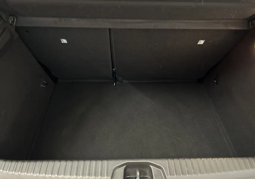 Coffre vide en vue plongeante d'une Renault Clio V blanche, montrant l'espace de chargement intérieur noir.