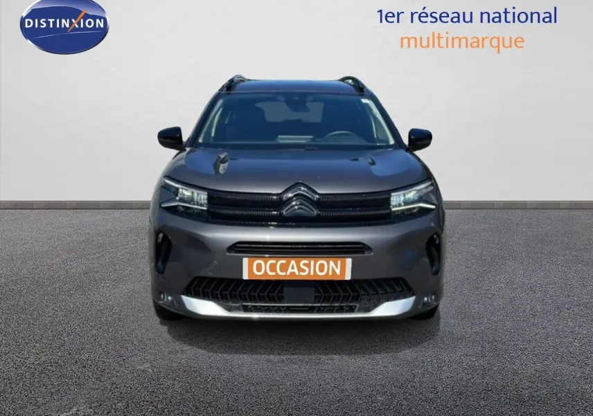 Vue frontale d'un Citroën C5 Aircross gris platinium métal 2025 avec calandre distinctive et feux LED allumés.