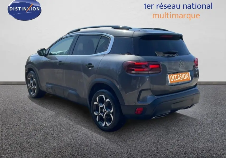 Vue 3/4 arrière droite du Citroën C5 Aircross gris platinium métal avec jantes bi-ton et toit panoramique.