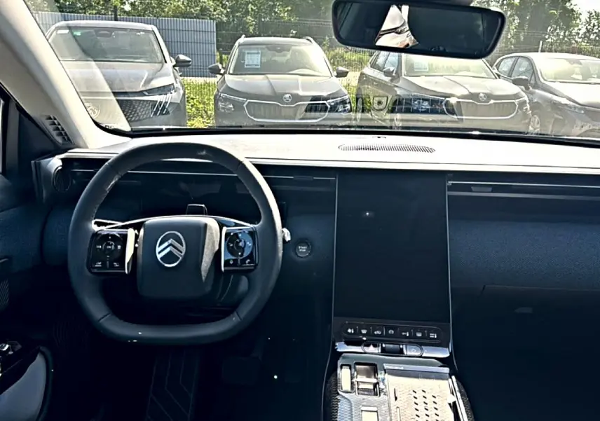 Vue intérieure frontale du tableau de bord et volant noir du Citroën C5 Aircross hybride 2026 avec écran tactile vertical.