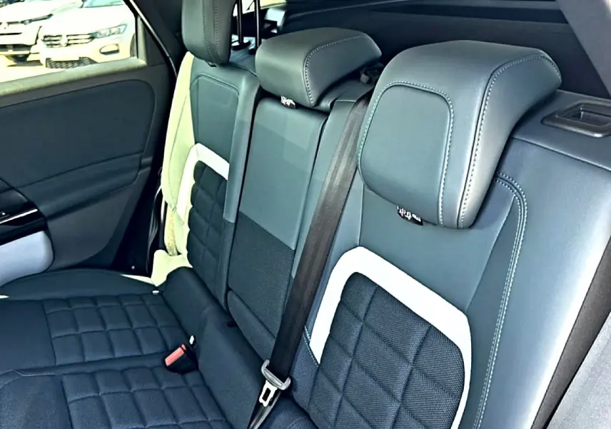 Vue intérieure sur la banquette arrière en cuir noir et gris du Citroën C5 Aircross, côté gauche, avec ceinture de sécurité visible.