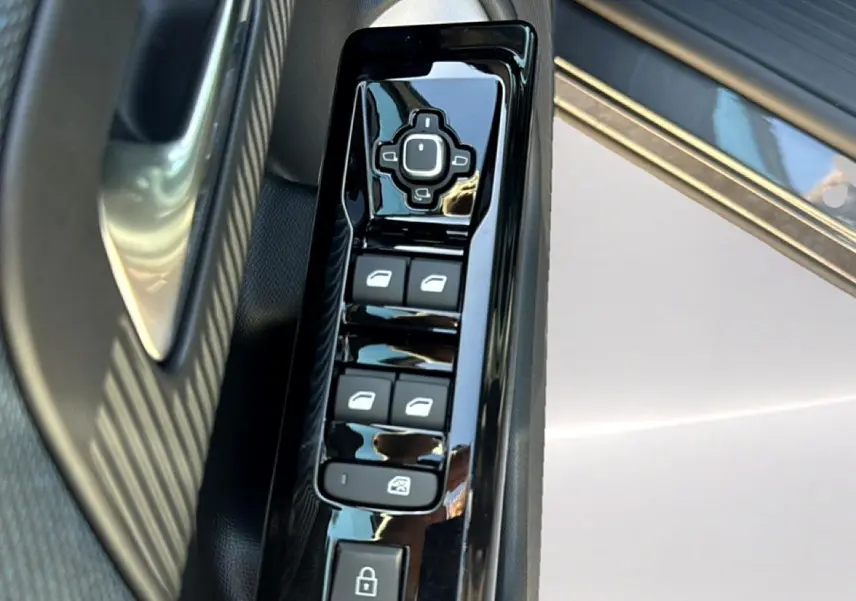 Gros plan sur la commande des vitres électriques côté gauche d'une Citroën C5 Aircross gris platinium avec insert noir brillant.
