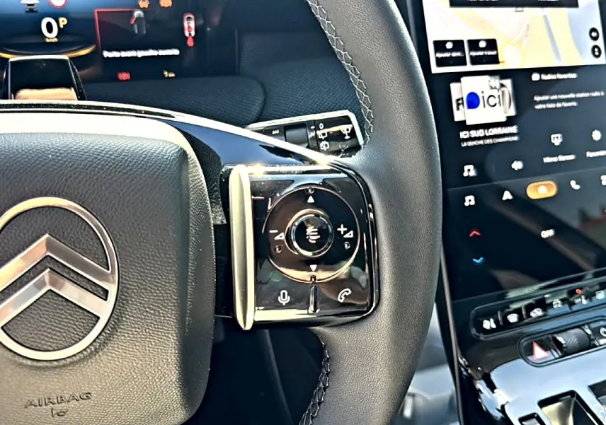 Gros plan sur le volant cuir noir avec commandes intégrées et écran tactile du tableau de bord du Citroën C5 Aircross 2026.
