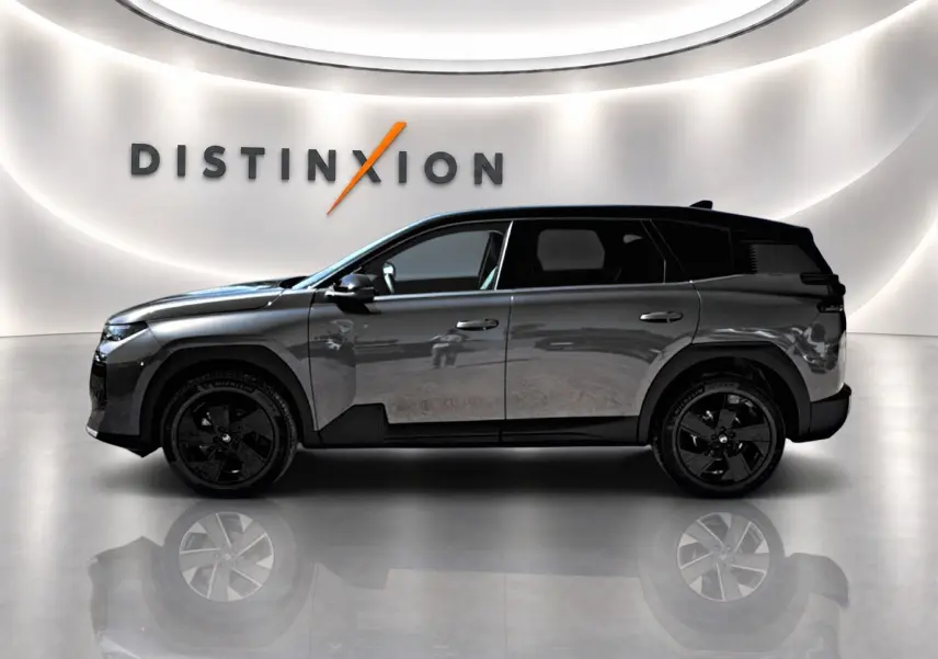 Profil droit du Citroën C5 Aircross 2026 gris platinium avec toit noir et jantes alliage noires dans un showroom lumineux.