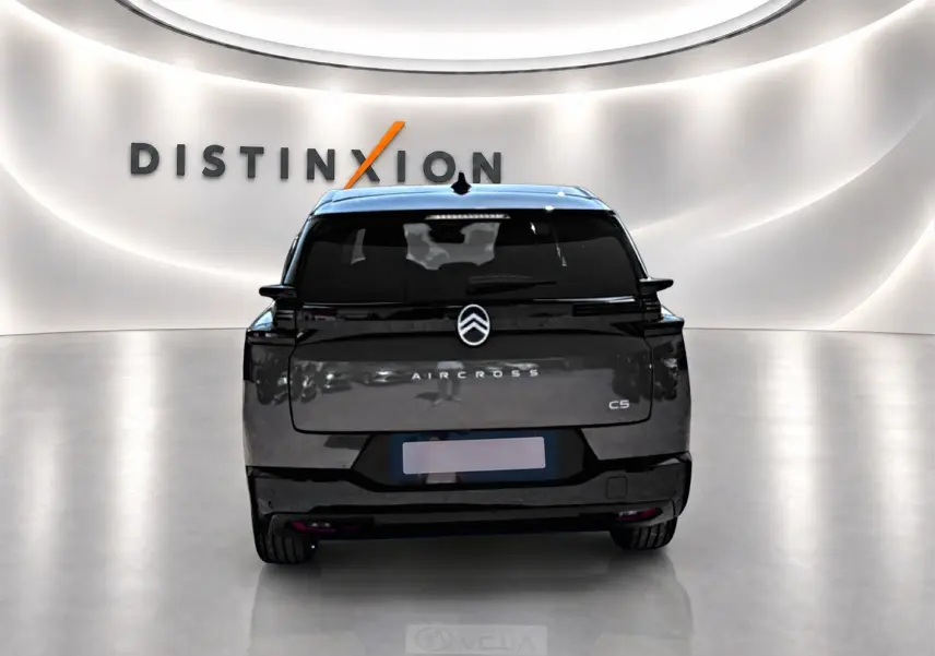 Vue arrière d'un Citroën C5 Aircross gris platinium avec toit noir dans un showroom lumineux Distinxion.