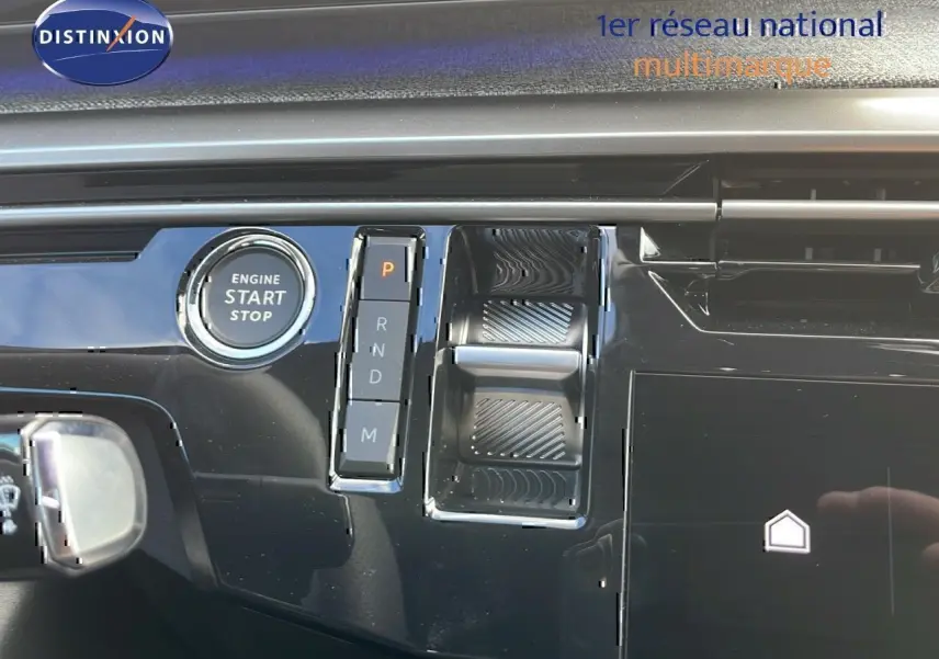 Gros plan sur la console centrale du Peugeot 3008 hybride 2025, montrant le bouton start/stop et la commande de boîte auto.