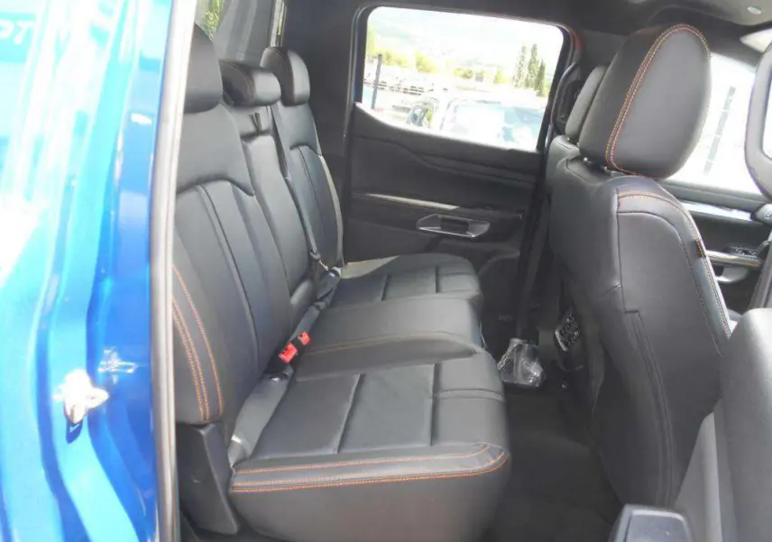 Vue intérieure côté gauche des sièges arrière en cuir noir avec surpiqûres orange du Ford Ranger 2025 Bleu Lightning Wildtrak Plus.