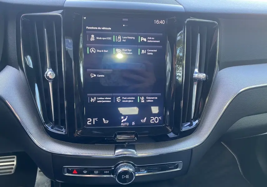 Écran tactile central du tableau de bord du Volvo XC60 blanc 2019, affichant les fonctions d'aide à la conduite.