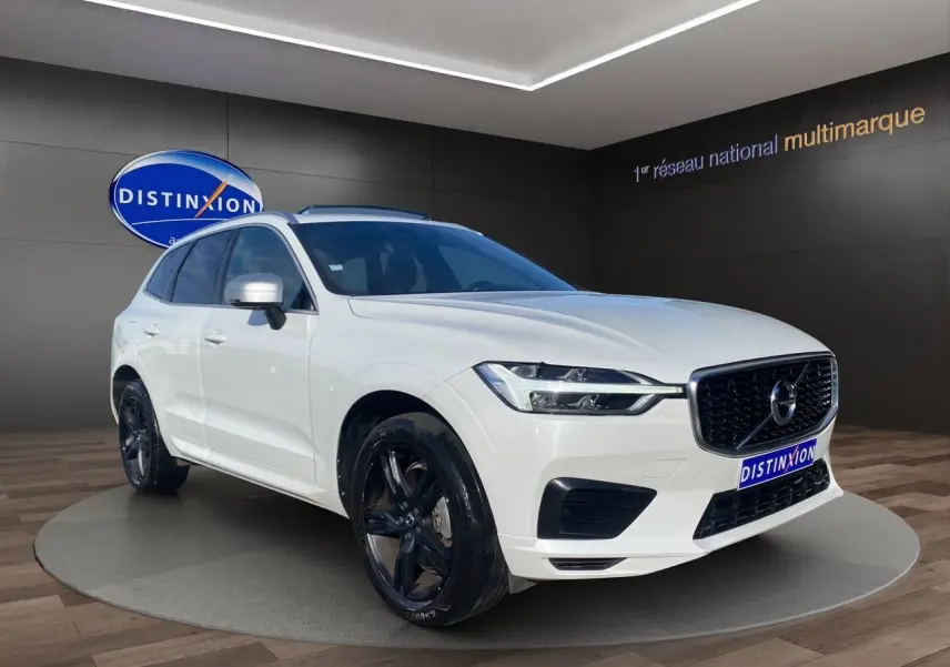 Vue 3/4 avant d'un Volvo XC60 blanc 2019 avec jantes noires et calandre noire R-Design.