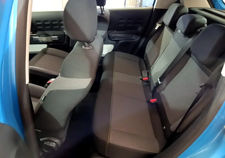 Vue intérieure côté droit sur les sièges arrière gris foncé d’une Citroën C3 bleu 2017 avec portes ouvertes.