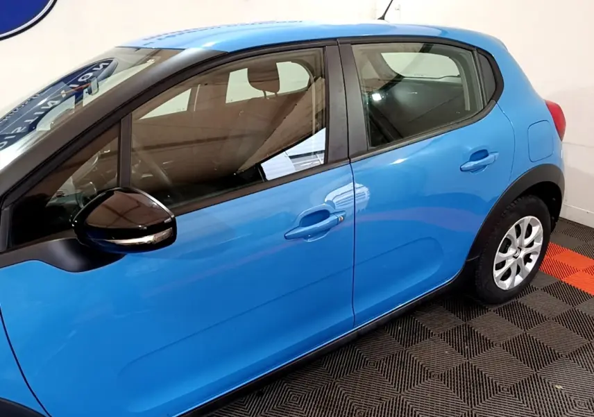 Vue latérale droite d'une Citroën C3 bleu vif avec rétroviseur noir et poignées de porte ton caisse.