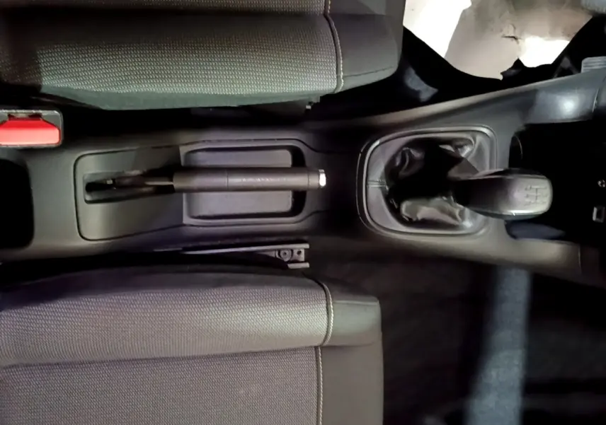 Vue plongeante sur la console centrale de la Citroën C3 bleu, montrant levier de vitesse manuel et frein à main.