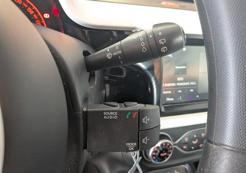 Gros plan sur la commande audio et essuie-glace à gauche du volant d'une Renault Twingo III gris cassiopée, intérieur 2021.