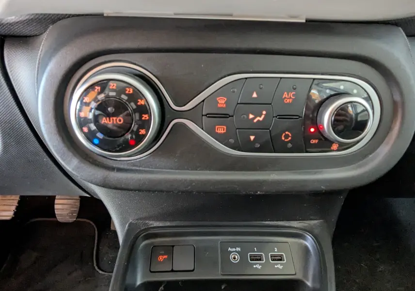 Vue rapprochée du tableau de bord de la Renault Twingo III 1.0 SCE 65 Limited, montrant les commandes de climatisation et les ports USB.