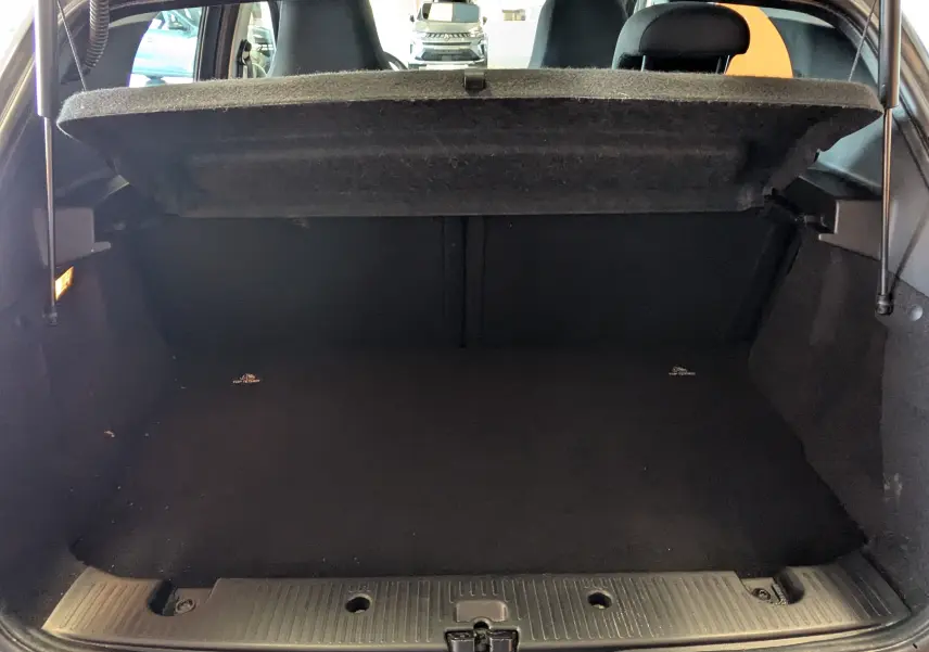 Vue intérieure du coffre ouvert de la Renault Twingo III gris Cassiopée, montrant l'espace de chargement vide.