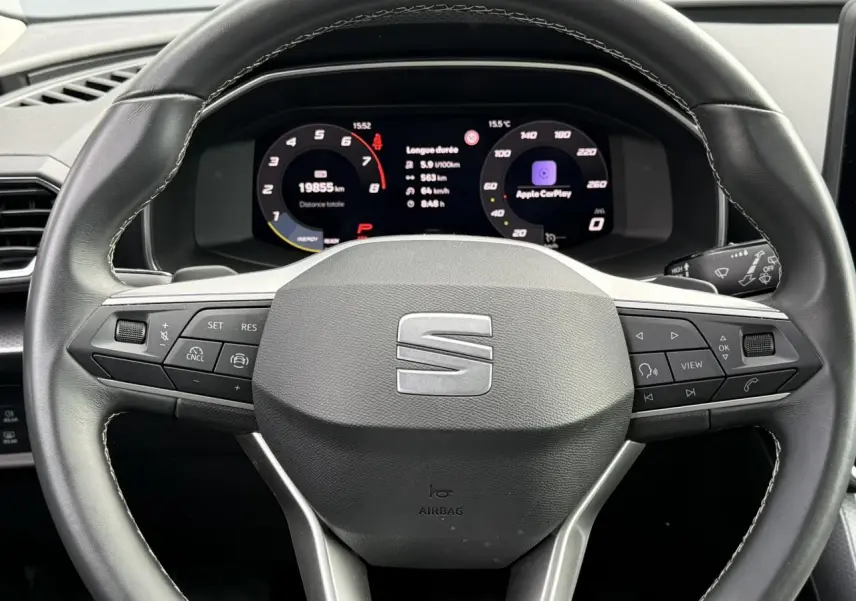 Vue rapprochée du volant cuir multifonction SEAT Leon 2025 avec tableau de bord digital affichant Apple CarPlay.