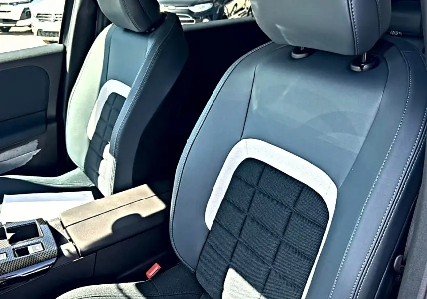 Gros plan sur les sièges avant bi-ton gris et noir du Citroën C5 Aircross 2026 avec accoudoir central et console.