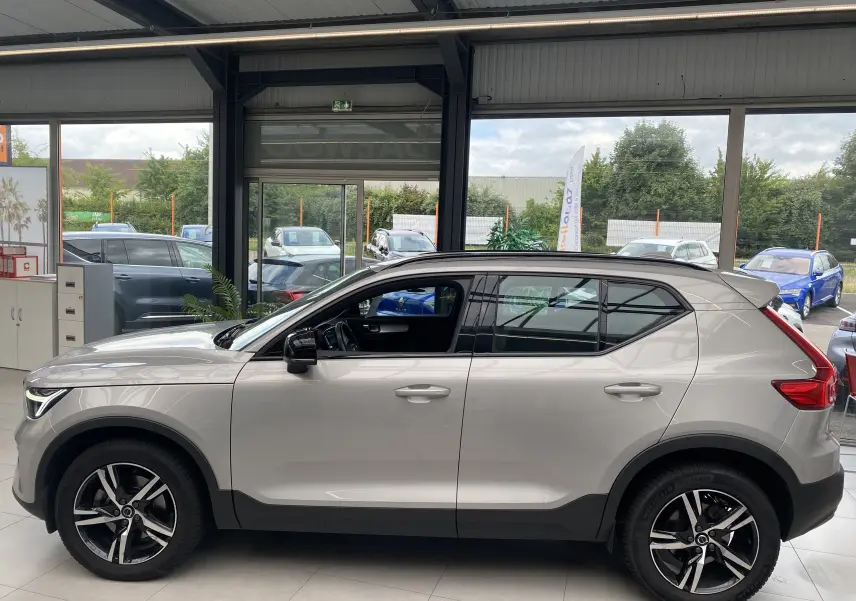 Profil côté gauche du Volvo XC40 B3 163ch Plus 2023 en argent aurore métallisé, avec jantes alliage et toit noir contrasté.
