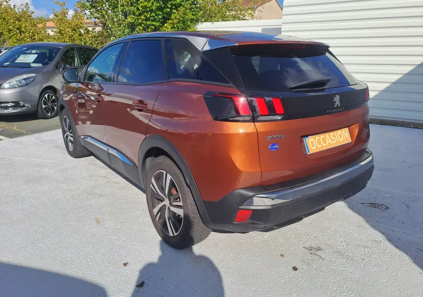 Vue 3/4 arrière droite d'un Peugeot 3008 2019 métallisé copper avec feux arrière à griffes et toit noir.
