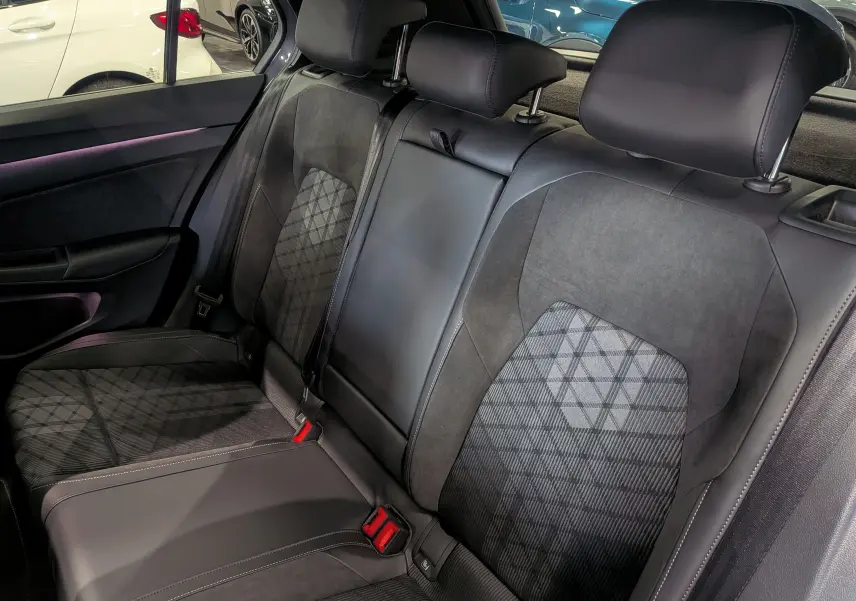 Vue rapprochée des sièges arrière en tissu et cuir noir de la Volkswagen Golf 1.5 eTSI R-Line 2025, intérieur soigné.
