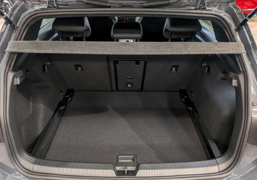 Coffre ouvert d'une Volkswagen Golf 1.5 eTSI gris dauphin, vue arrière montrant l'espace de chargement et les sièges arrière.