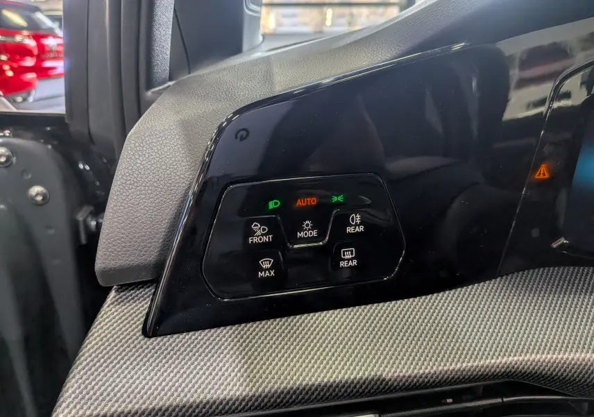 Panneau de commandes d’éclairage avec mode automatique sur tableau de bord gris d’une Volkswagen Golf 2025.