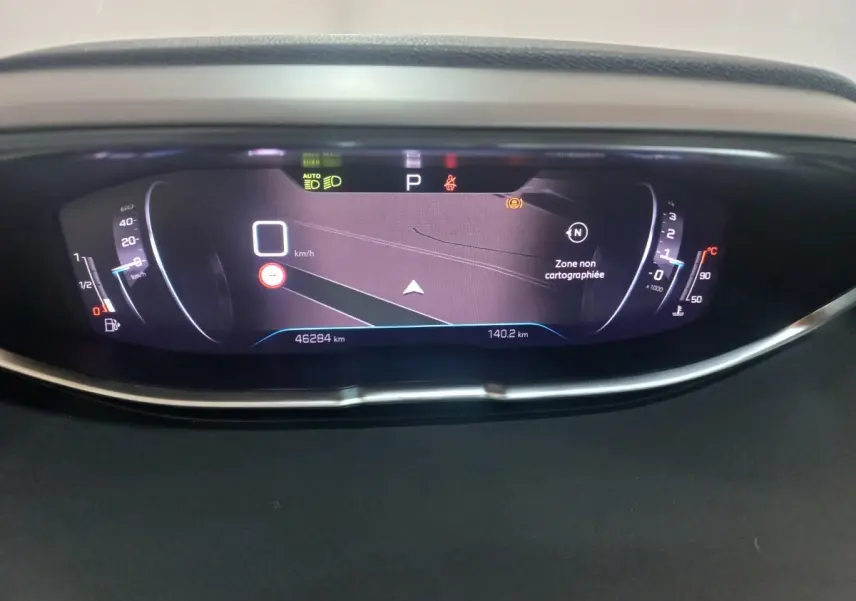 Vue rapprochée du tableau de bord numérique du Peugeot 3008 gris clair, affichant la navigation et les compteurs.
